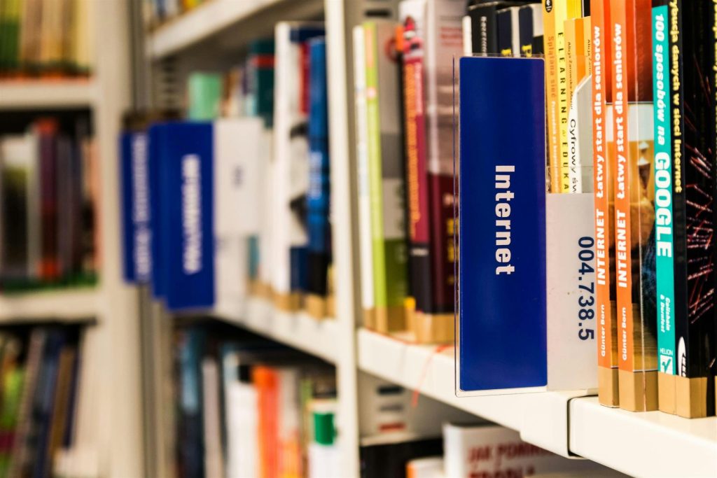 Close-up of a library shelf with books on internet and technology. Ideal for education-themed projects.